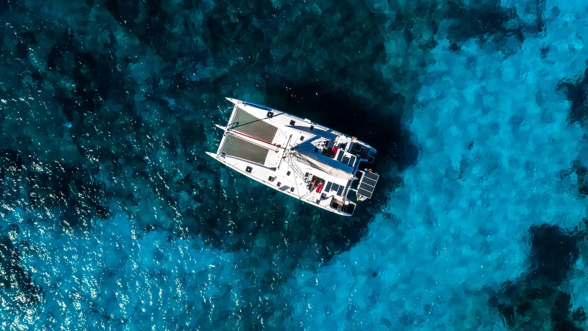 Private charter Malta: luxury yacht sailing at sunset with couple relaxing on deck in the Mediterranean