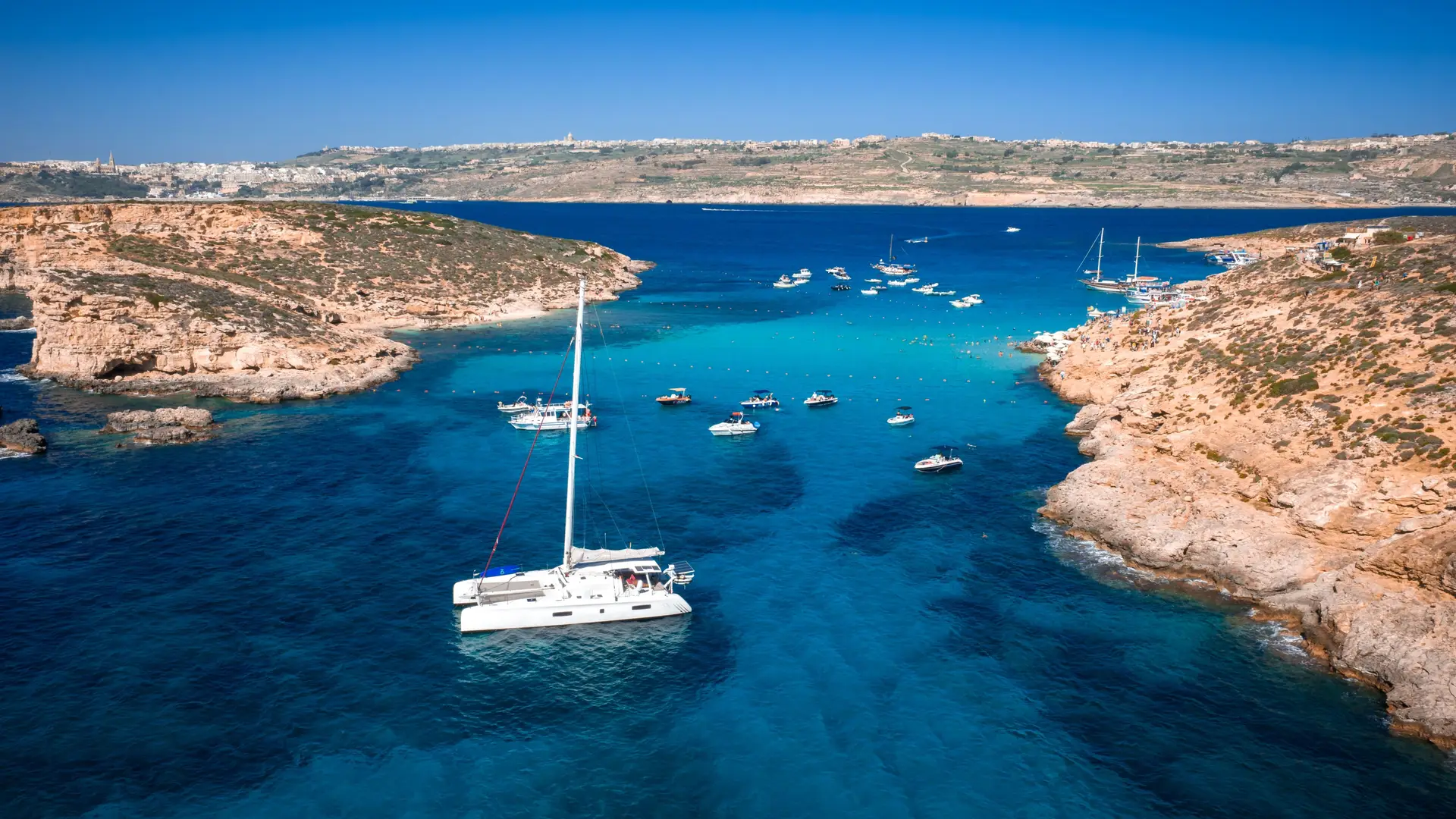 Private charters Malta: luxury yacht at sunset with couple celebrating on the flybridge in the Mediterranean