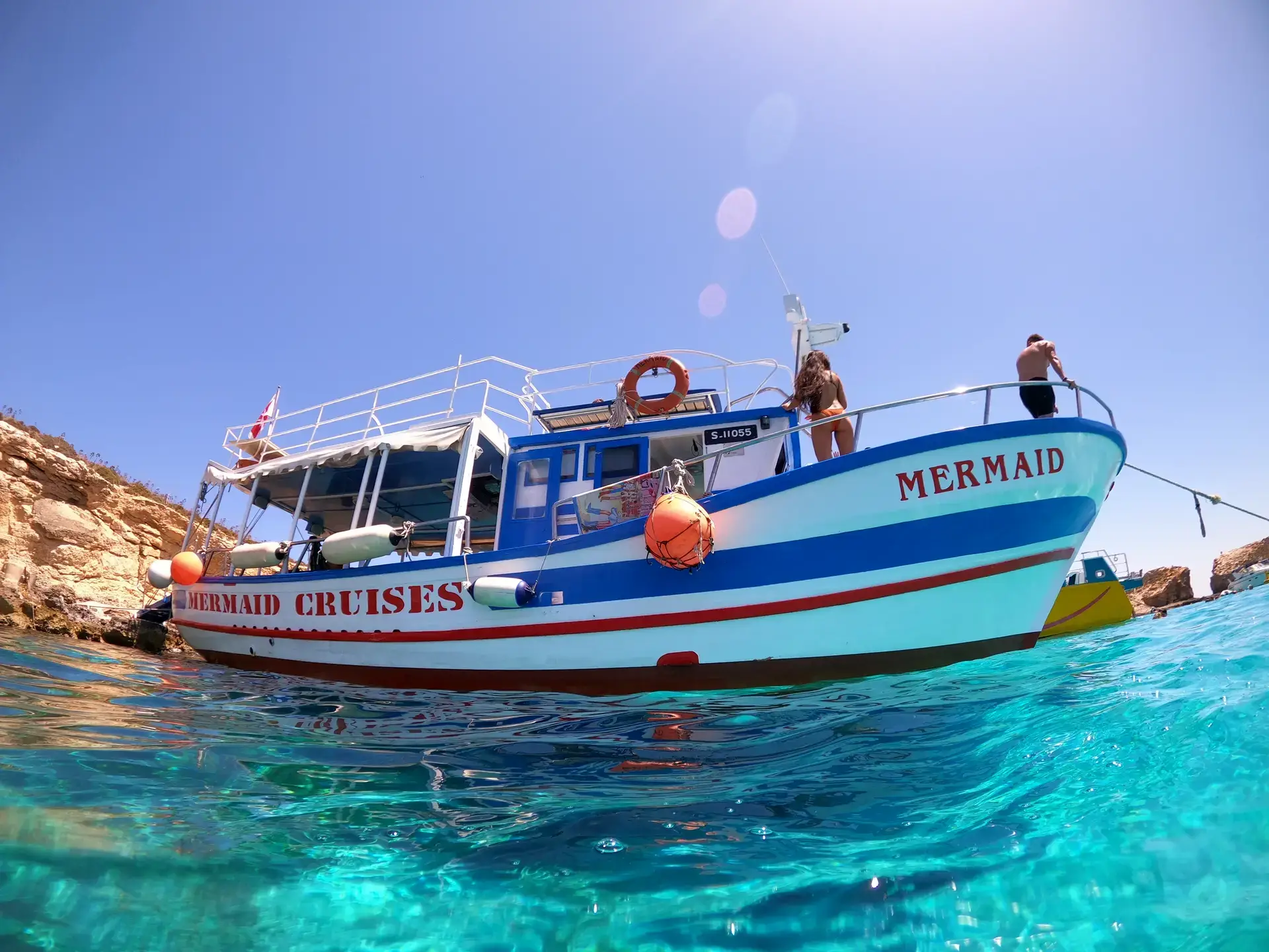 Stunning turquoise waters of the Blue Lagoon during one of the most popular Blue Lagoon boat tours and Comino boat tours in Malta, with visitors swimming and boats anchored in Comino’s crystal-clear lagoon.